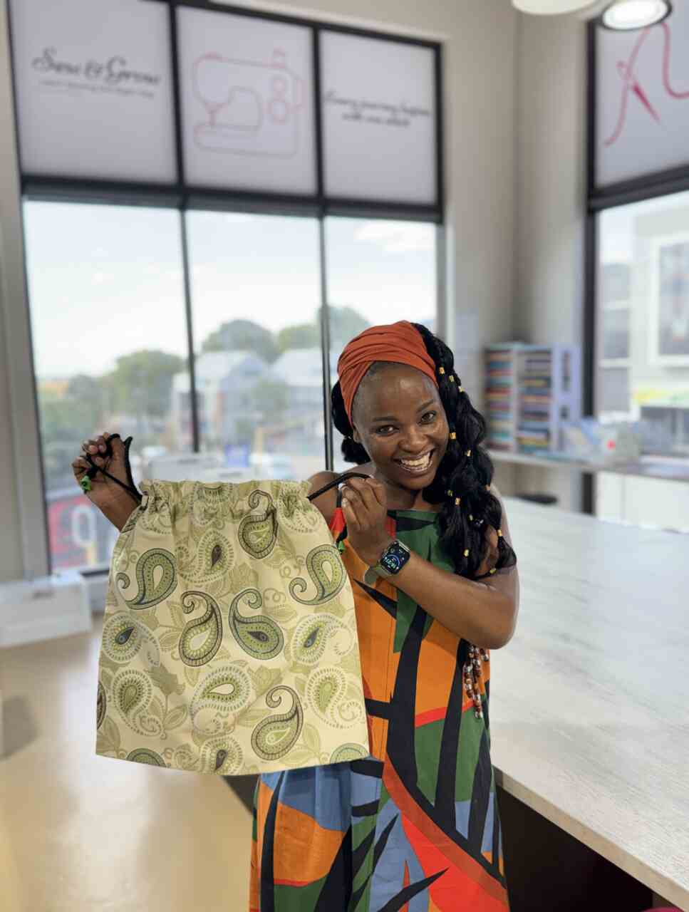 Student proudly holding her first drawstring bag