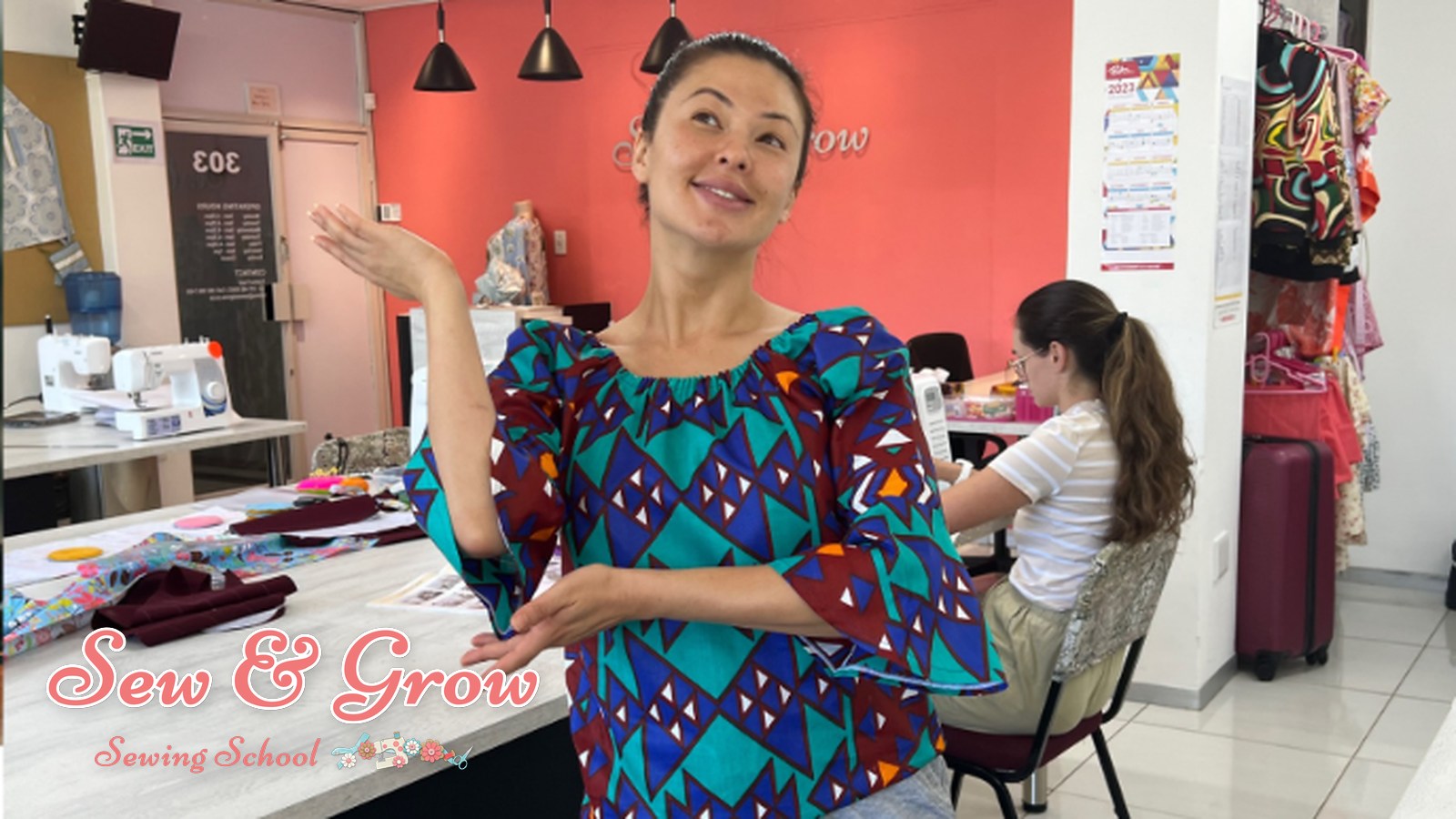 A proud graduate holding a garment they made
