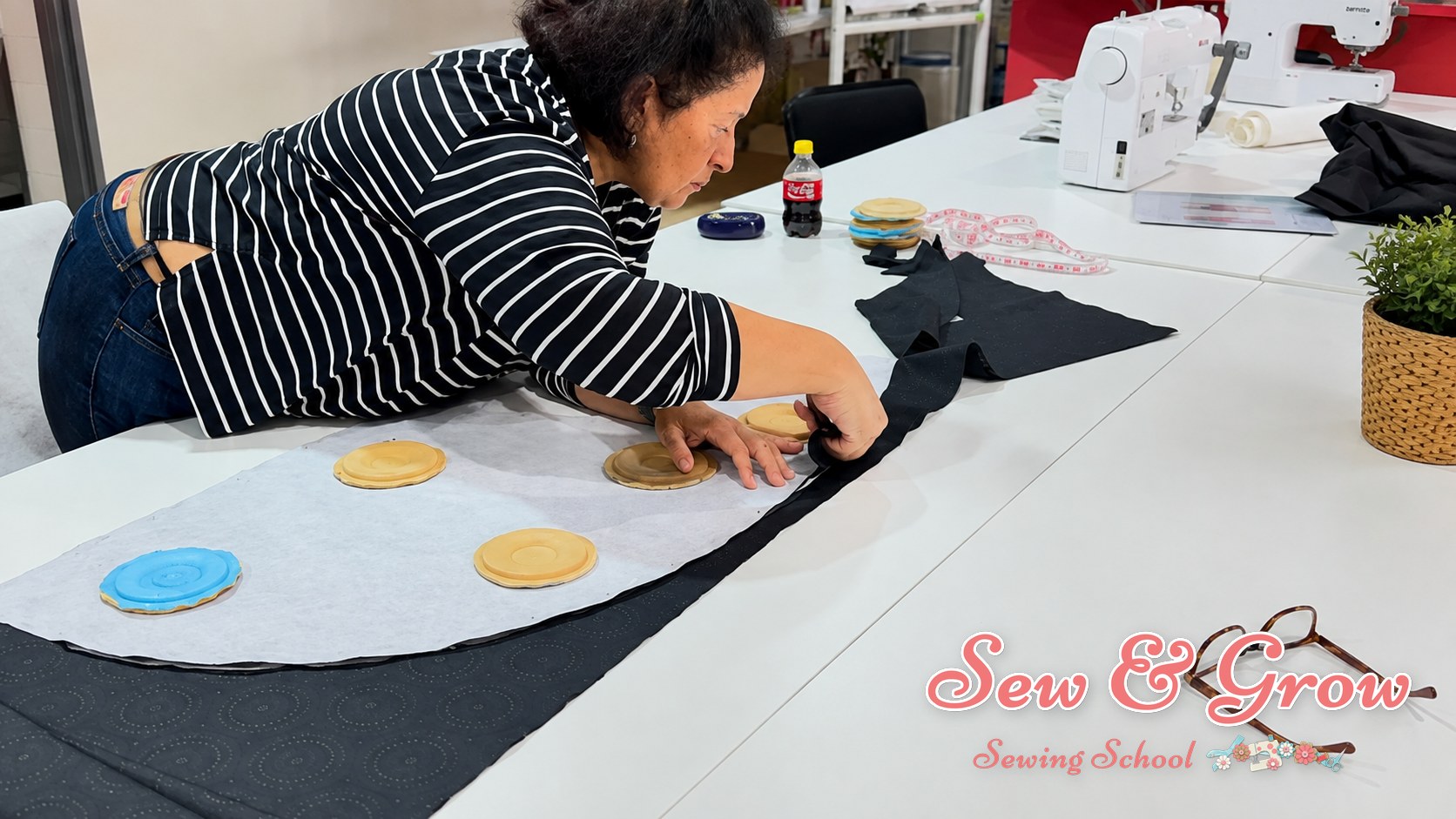A beginner's hands being guided at a sewing machine