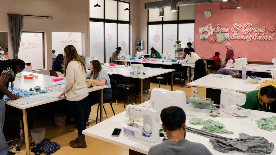 A busy class with students sewing at every station